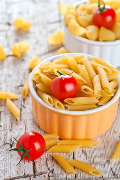 Uncooked pasta and cherry tomatoes — Stock Photo, Image