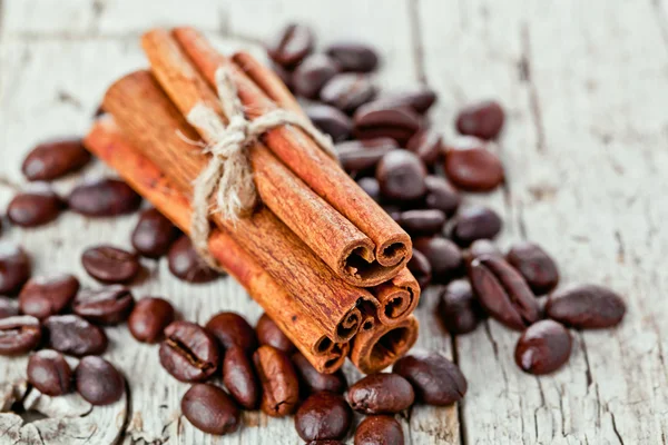 Pila de palitos de canela y granos de café — Foto de Stock