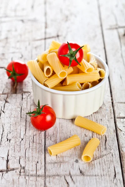 Uncooked pasta and cherry tomatoes in a bowl — Stock Photo, Image