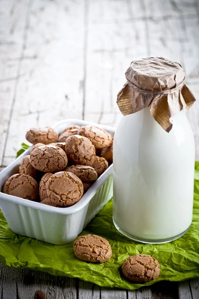 Baiser-Mandelplätzchen in einer Schüssel und einer Flasche Milch — Stockfoto