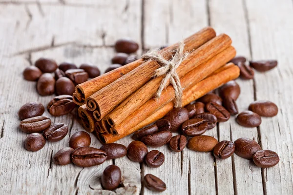 Stack of cinnamon sticks and coffee beans — Stock Photo, Image