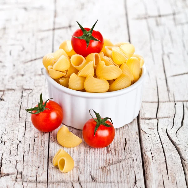 Uncooked pasta and cherry tomatoes in a bowl — Stock Photo, Image