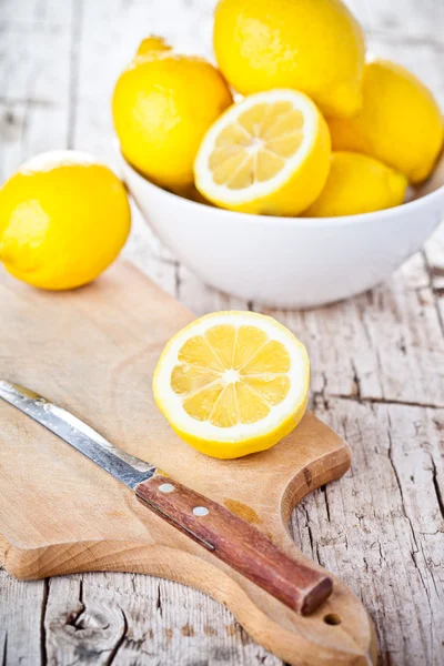 Fresh lemons in a bowl and knife — Stock Photo, Image