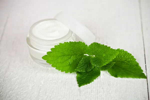 Face cream in glass jar with green leaf of urtica — Stock Photo, Image