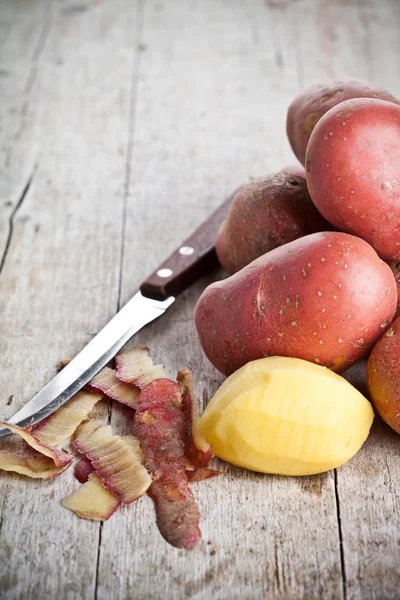 Peeled potatoes and knife — Stock Photo, Image