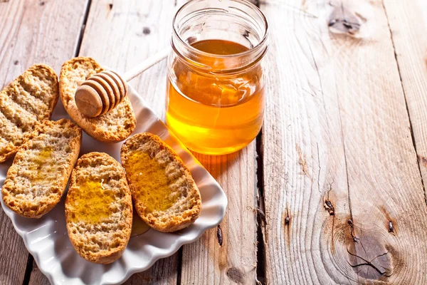 Crackers in plate and honey — Stock Photo, Image