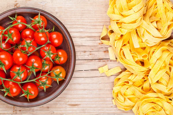 Uncooked pasta and fresh tomatoes — Stock Photo, Image