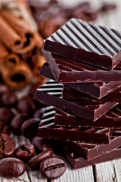 Čokoládové cukrovinky, skořice a kávové boby — Stock fotografie
