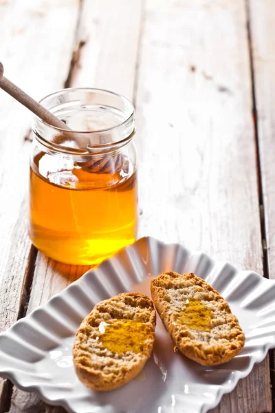 Kjeks i tallerkener og honning – stockfoto