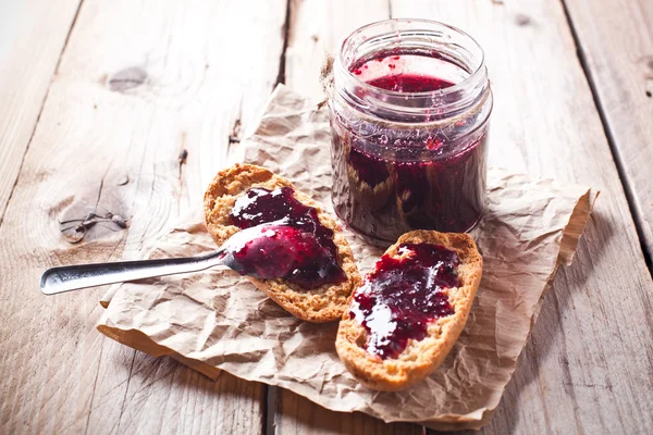 Black currant jam in glass jar and crackers Royalty Free Stock Photos