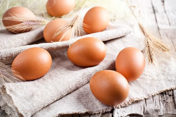 Uova marroni fresche e spighe di grano — Foto Stock