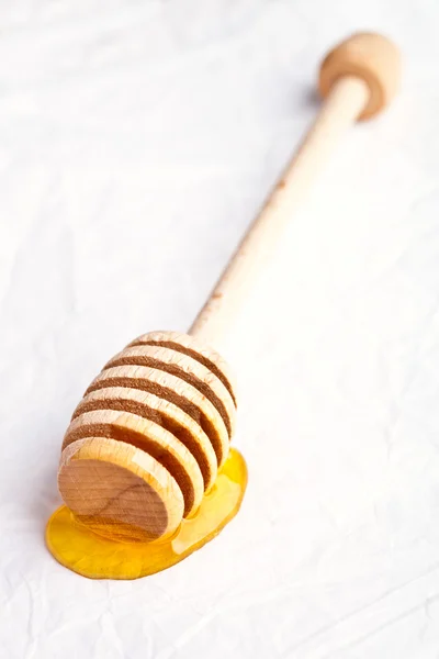 Honey on wooden honey dipper — Stock Photo, Image