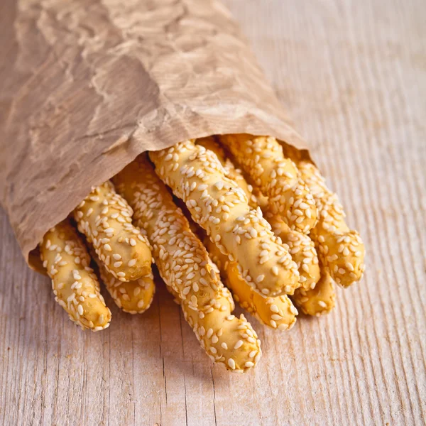 Bâtonnets de pain grissini avec graines de sésame dans un emballage artisanal — Photo