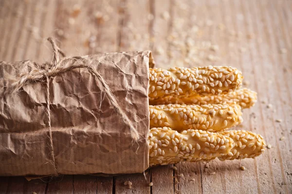 Bâtonnets de pain grissini avec graines de sésame dans un emballage artisanal — Photo