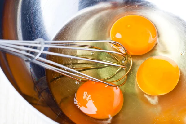 Whisking eggs in metal bowl — Stock Photo, Image
