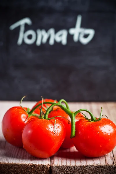Świeże pomidory i tablica — Zdjęcie stockowe