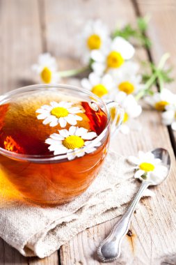 Papatya çiçekli bir fincan çay.
