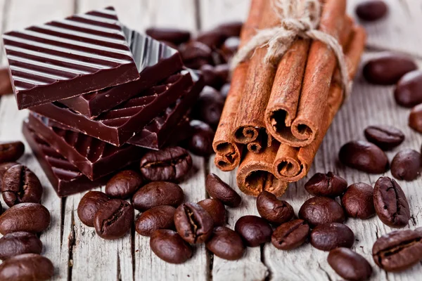 Schokoladenbonbons, Zimt und Kaffeebohnen — Stockfoto