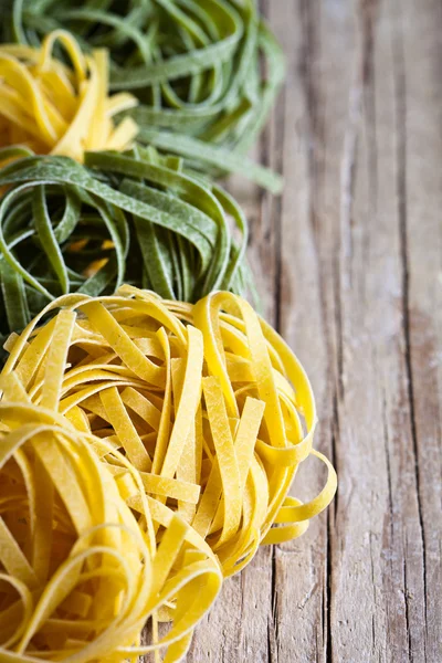 Pasta amarilla y verde sin cocer tagliatelle —  Fotos de Stock