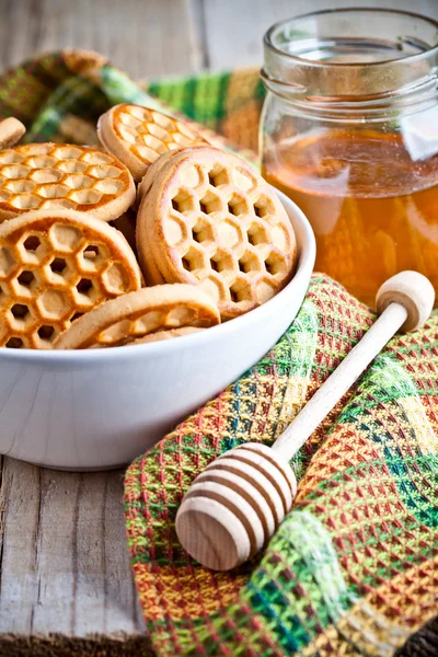 Fresh cookies in a bowl, tablecloth and honey — Stock Photo, Image