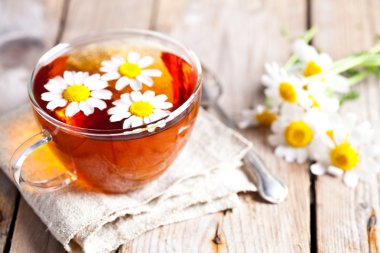 Papatya çiçekli bir fincan çay.