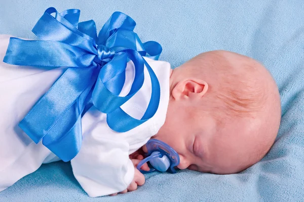 The sleeping kid with a blue bow — Stock Photo, Image