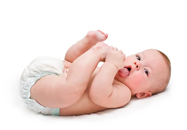 Kid lying on a back, licks the foot — Stock Photo, Image
