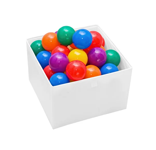 Muchas bolas de plástico de color en caja en blanco — Foto de Stock