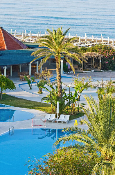 Hotel pool on a sunny day, sea on background