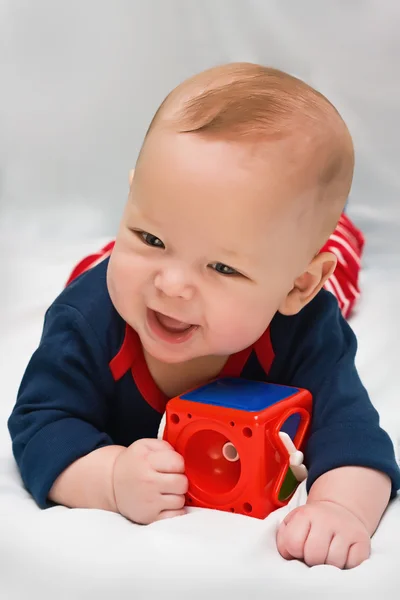 De jongen met een stuk speelgoed op een lichte achtergrond — Stockfoto