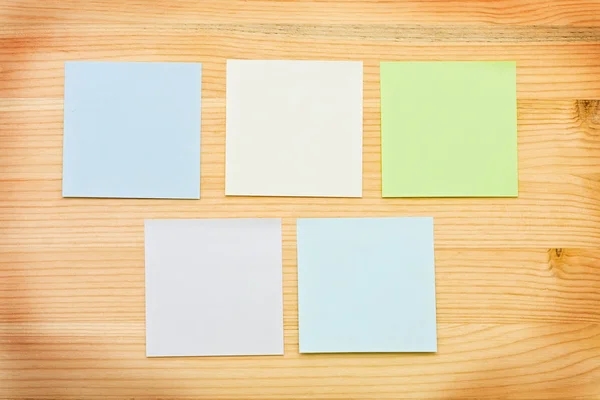 Multi-colored notes on a wooden background — Stock Photo, Image
