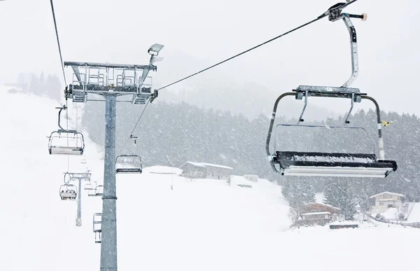 Skilift stoelen kirhberg, Oostenrijk. sneeuwval — Stockfoto