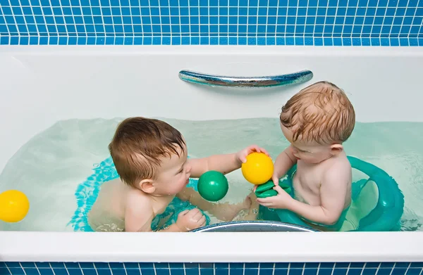One-year-old twins play a bathroom
