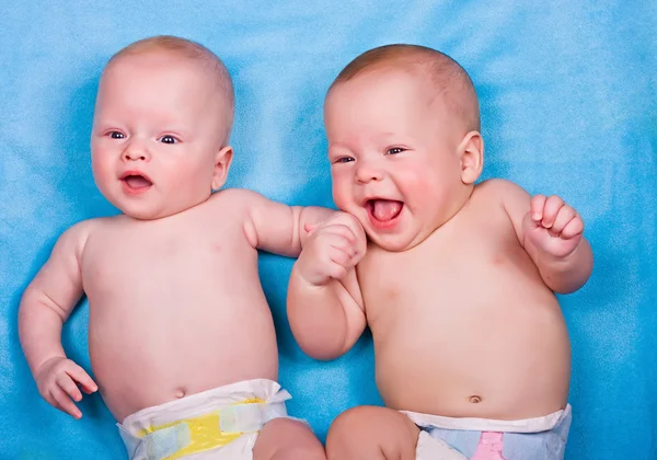 Two babies - one looking, one smiling — Stock Photo, Image