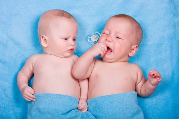 2 つの赤ちゃん - 1 つを見ると、1 つで泣いています。 — ストック写真