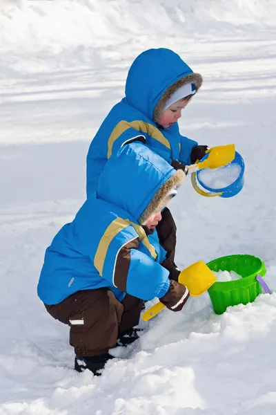 Gêmeos de um ano jogam na neve — Fotografia de Stock