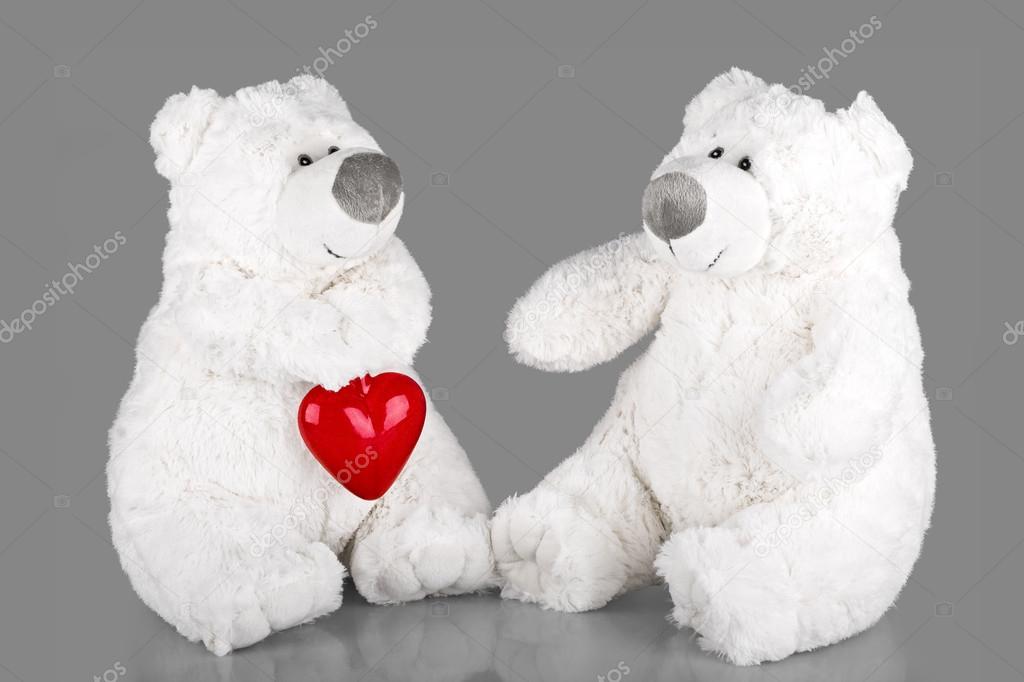 Teddy bears with red heart on grey background