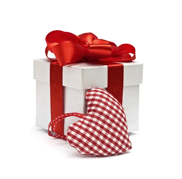 Červený dárek a textilní pestré srdce — Stock fotografie