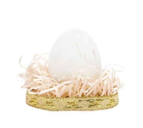 Œuf blanc dans un nid avec ruban d'or — Photo