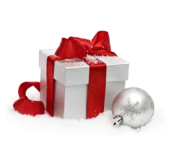 White gift box with red bow and snow — Stock Photo, Image