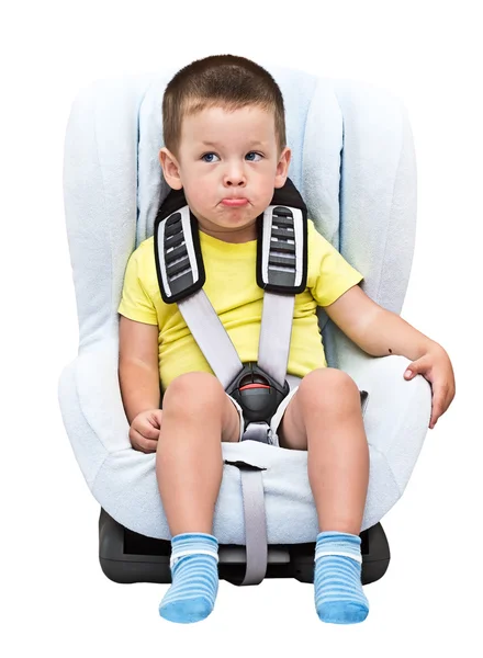 Boy sits in an automobile children's chair — Stock Photo, Image