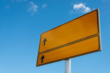 gökyüzü arka plan üzerindeki oklarla sarı yol işareti.