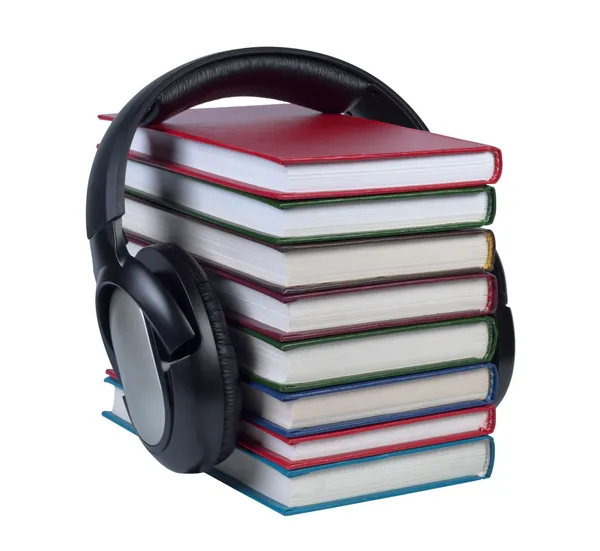 Headphones worn on a stack of books with color covers. — Stock Photo, Image