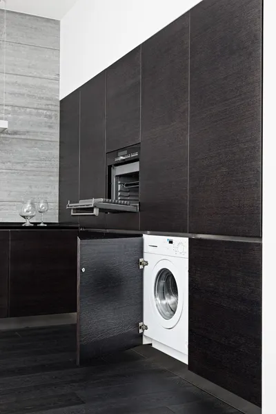 Build-in máquina de lavar roupa e fogão na cozinha preta moderna — Fotografia de Stock