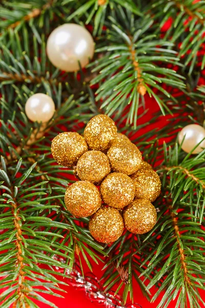 Decoraciones de Navidad y rama de abeto sobre fondo rojo —  Fotos de Stock