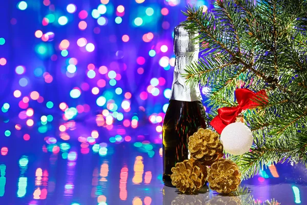 Christmas tree decorations with spruce and champagne on bokeh ba — Stock Photo, Image