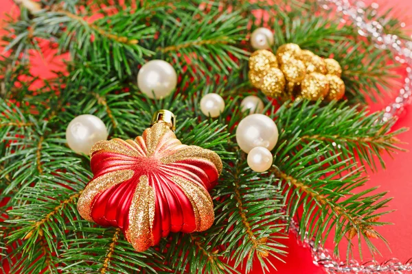 Decorazioni di Capodanno con ramoscello di abete rosso su sfondo rosso — Foto Stock