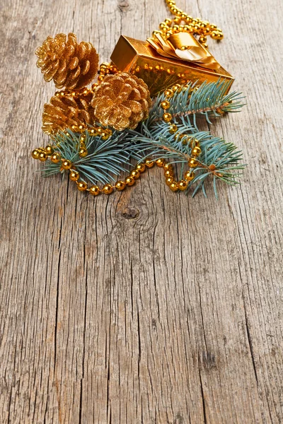 Gouden kerstversiering op pine tak op houten achtergrond — Stockfoto