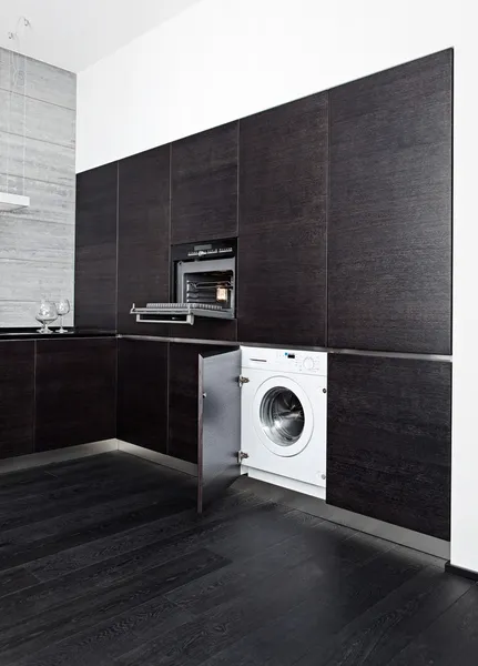 Встроенная стиральная машина и плита на современной черной кухне — стоковое фото