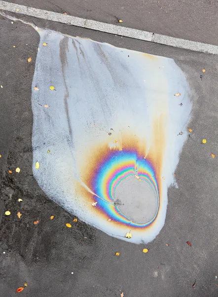Gasoline (oil) spot on asphalt sidewalk surface — Stock Photo, Image